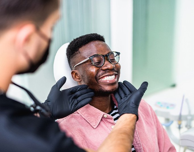 Dentist looking at patient's smile in treatment room