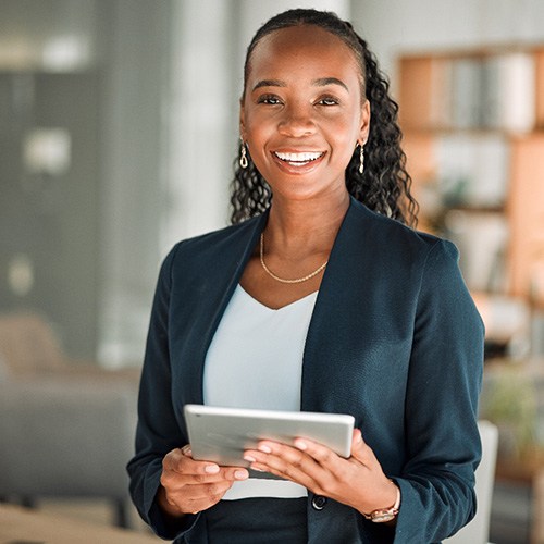 Smiling woman holding tablet in office
