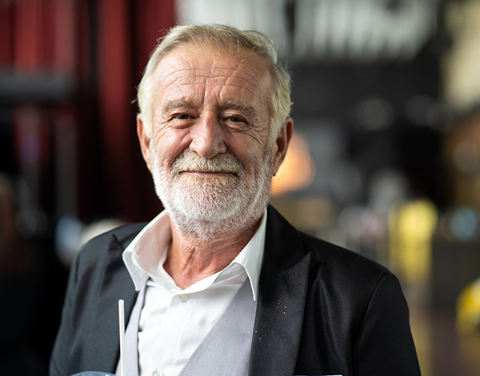 Senior man smiling with his lips closed