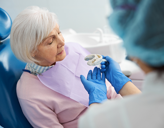 Senior woman getting an impression of her teeth taken for dentures in Windermere