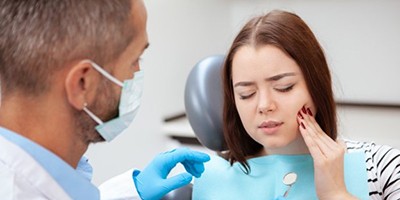 young woman with toothache talking to her emergency dentist in Windermere 