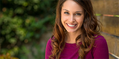 A woman smiling outside.