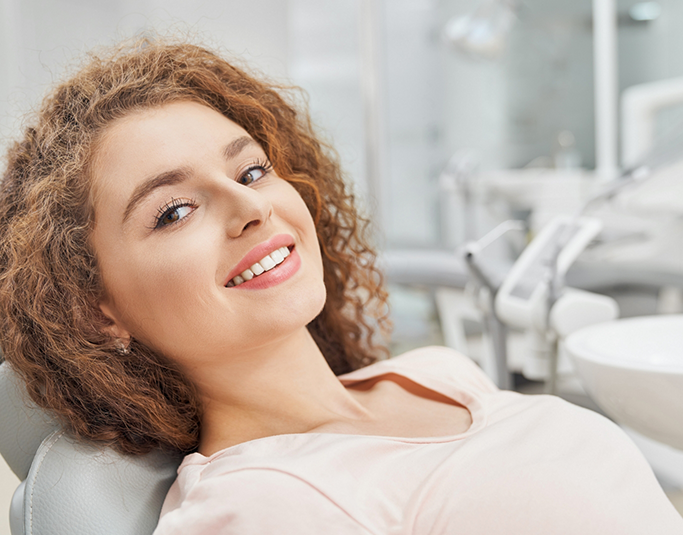 Smiling woman leaning back in the dental chair