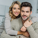 Smiling man and woman embracing at home