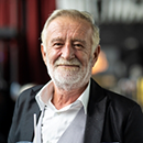 Older man smiling with his lips closed