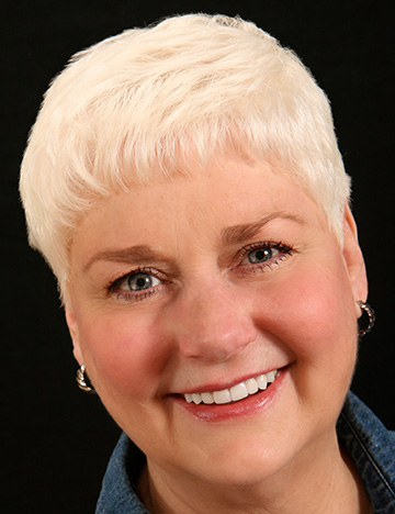 Woman with short blonde hair smiling with whiter and evenly spaced teeth