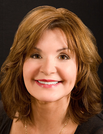 Brunette woman smiling after cosmetic dental treatment