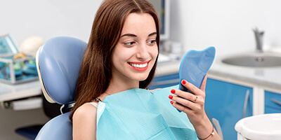 woman checking smile in mirror