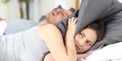 man snoring annoying woman in bed 