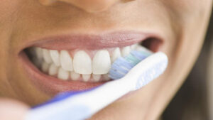 person brushing their teeth in the mirror