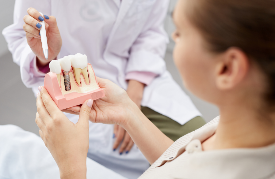 Dentist showing patient dental implant model