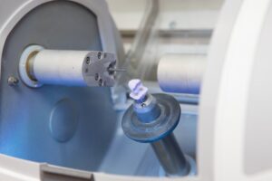Dental crown being manufactured by machine.