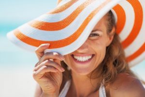 Smiling woman wearing sun hat.