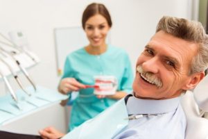 Man smiling and receiving dentures.