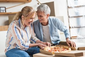 People with dentures enjoying a pizza.