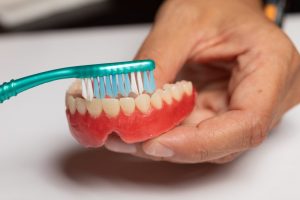 A dentist cleaning dentures in Windermere