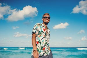 a man smiling at the beach after getting veneers